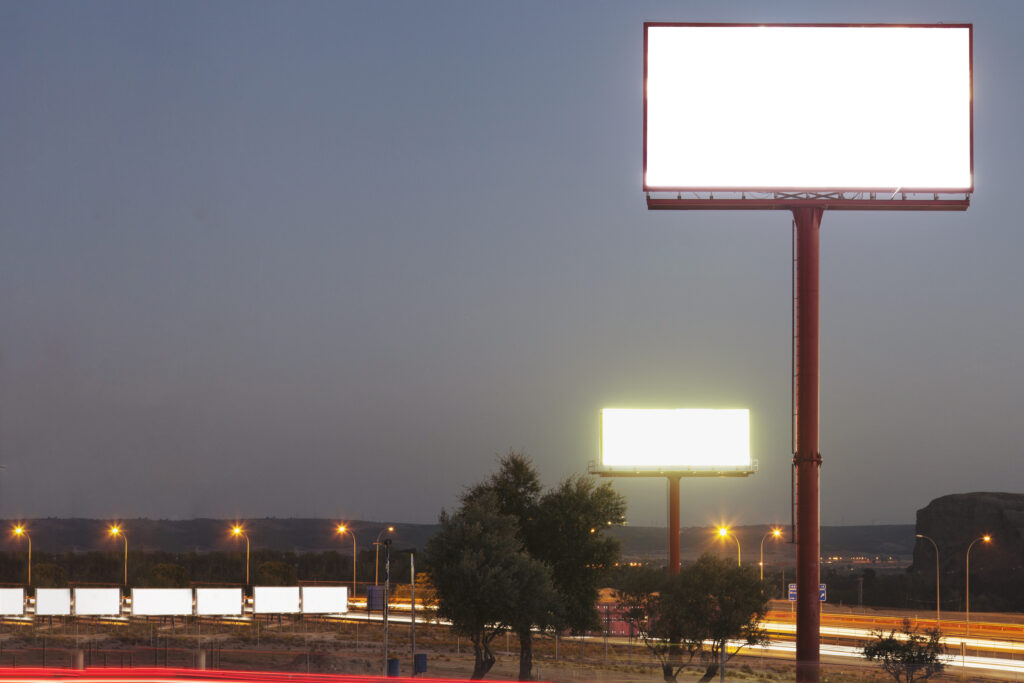 white blank billboard over the illuminated highway during night